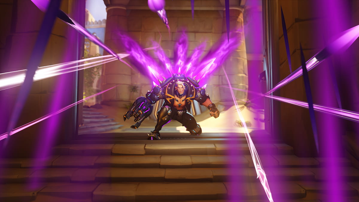 Screenshot of Hazard in Overwatch 2 using his Ultimate Ability, Downpour. He shoots purple spikes from a contraption on his back, stunning any enemy players within the area of effect and preventing them from moving.